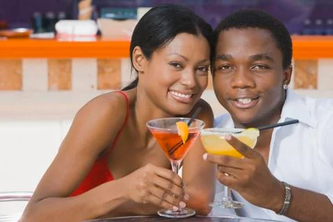 Multi-ethnic couple toasting with cocktails Stock Photos