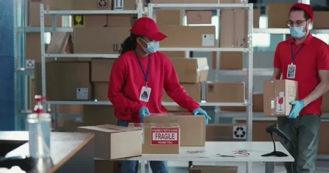 Multi-Ethnic Couple of Young Workers in Post Office Wearing Masks Communicating Stock Footage 150513192