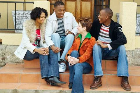 Multi-ethnic couples sitting on porch steps Stock Photos