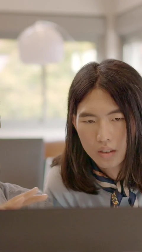 Multi-ethnic coworkers using computer and talking in the office Stock Footage 262231713