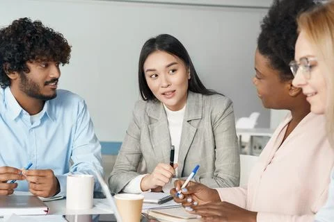 Multi-ethnic diverse students working on common project sitting at desk in class Stock Photos