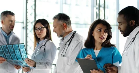 Multi ethnic doctors, men and women, talking and discussing diagnosis in clinic Stock Footage 140760914