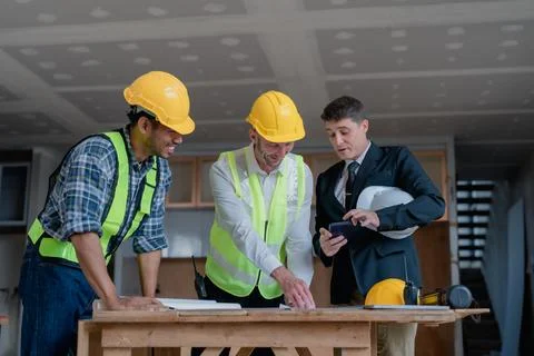 Multi ethnic engineer brainstorming and measuring for cost estimating on Stock Photos
