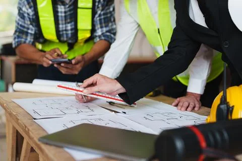 Multi ethnic engineer brainstorming and measuring for cost estimating on Stock Photos
