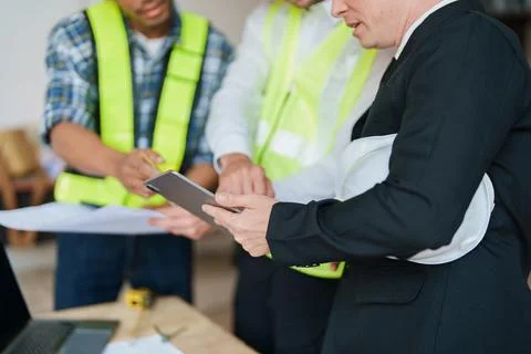 Multi ethnic engineer brainstorming and measuring for cost estimating on Stock Photos