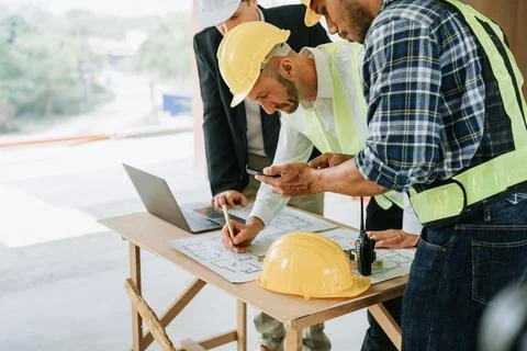 Multi ethnic engineer brainstorming and measuring for cost estimating on bl.. Stock Photos