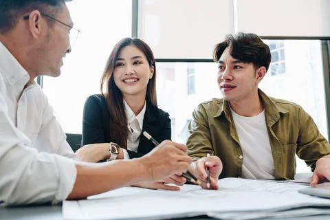 Multi ethnic engineer brainstorming and measuring for cost estimating on pa.. Stock Photos