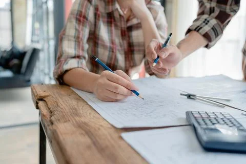 Multi ethnic engineer brainstorming and measuring for cost estimating on Stock Photos