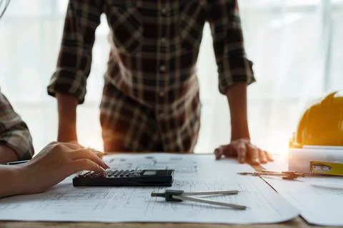 Multi ethnic engineer brainstorming and measuring for cost estimating on Stock Photos
