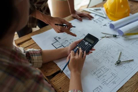 Multi ethnic engineer brainstorming and measuring for cost estimating on Stock Photos