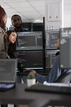 Multi ethnic engineers analyzing server code and database Stock Photos