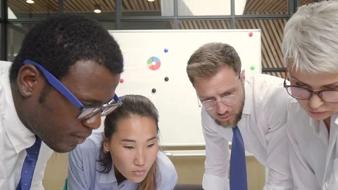 Multi-ethnic executive team finishing house blueprint in office. Stock Footage 101788644