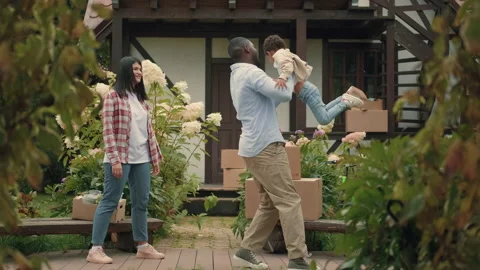 A multi-ethnic family is playing while moving into a new purchased house Video stock 210512216