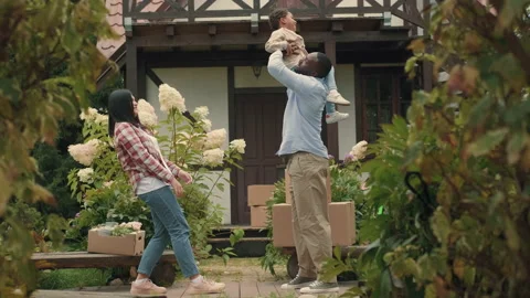 A multi-ethnic family is playing while moving into a new purchased house Stock Footage 210514582