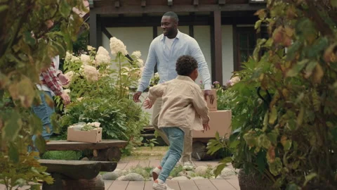 A multi-ethnic family is playing while moving into a new purchased house Stock Footage 210516877