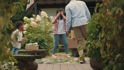 A multi-ethnic family is playing while moving into a new purchased house Stock Footage 210518277