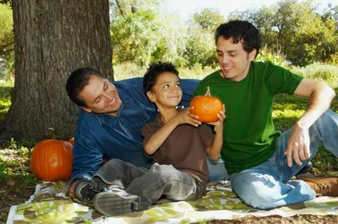 Multi-ethnic family with pumpkins under tree Stock Photos