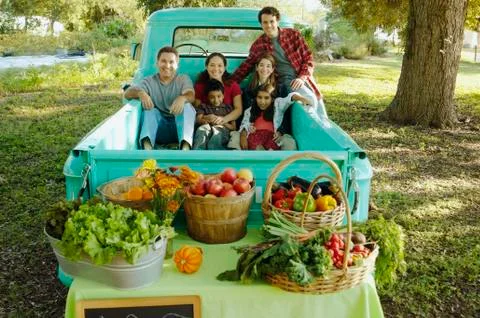 Multi-ethnic family in truck at farm stand Stock Photos