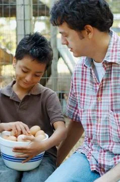 Multi-ethnic father and son with bowl of eggs Stock Photos
