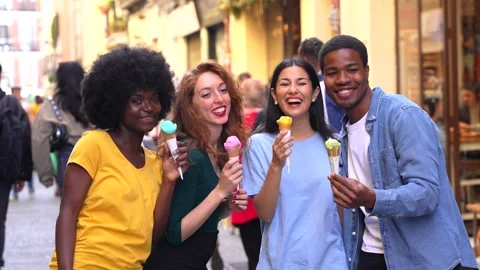 Multi-ethnic friends eating an ice cream cone, summer fun, walking down the.. Stock Footage 235906753