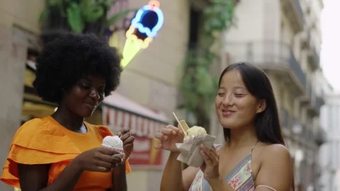 Multi-ethnic friends eating an ice cream in the street Stock Footage 255552923