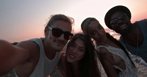 Multi-ethnic friends having fun taking selfies on beach at sunset Stock Footage 83216411