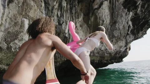 Multi ethnic friends jumping off authentic long tail boat into ocean, three frie Stock Footage 201095535