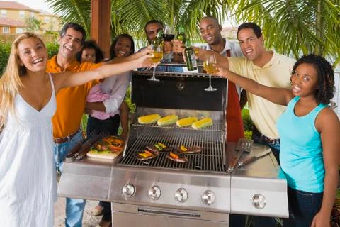 Multi-ethnic friends toasting over barbecue grill Stock Photos