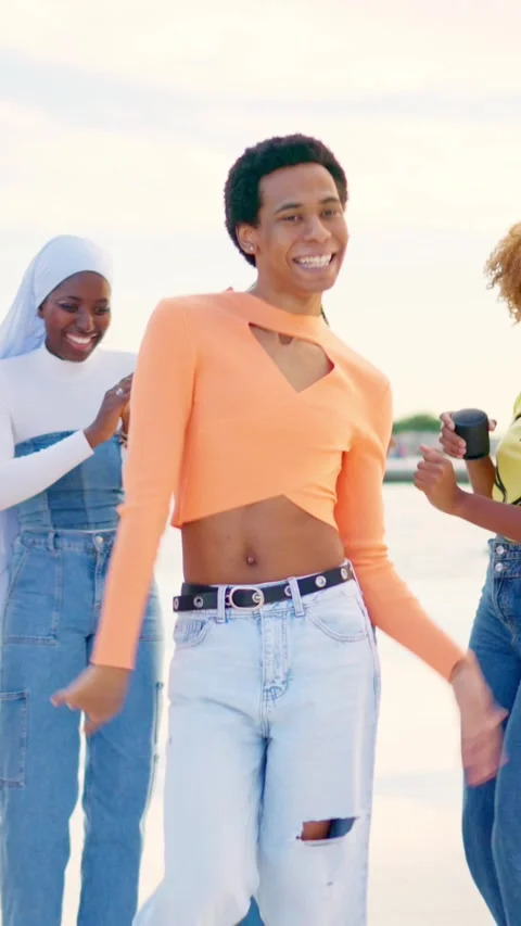 Multi-ethnic friends turning to dance freestyle next to the sea Stock Footage 264375099