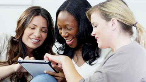 Multi ethnic girlfriends have fun online socializing with tablet   Stock Footage