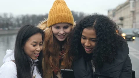 Multi Ethnic Girls Having Fun Using Smart Phone Technology In City Stock Footage 98565411