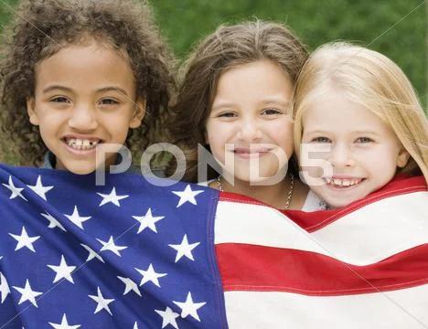 Multi-ethnic girls holding American flag Stock-Fotos