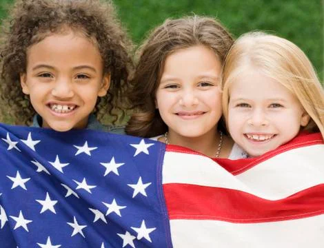 Multi-ethnic girls holding American flag Stock Photos