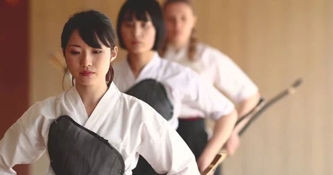 Multi-ethnic group of athletes practicing Japanese traditional Kyudo archery Видео 78078773
