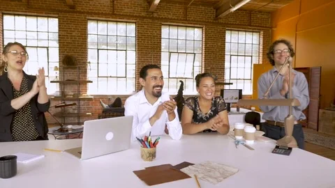 Multi ethnic group of coworkers clapping and cheering at business startup Stockbeeldmateriaal 78916938