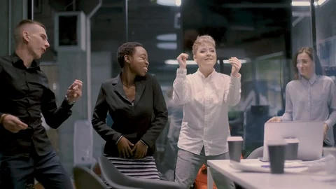 A multi-ethnic group of five businessmen is dancing in the office and rejoices Stock Footage 120972641