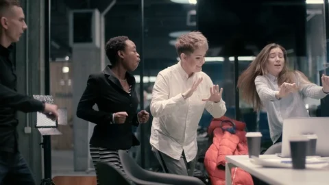A multi-ethnic group of five businessmen is dancing in a meeting room and Stock Footage 120972790