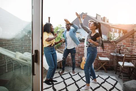 Multi ethnic group of friends dancing on rooftop 스톡 사진