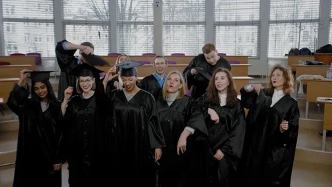 Multi ethnic group of graduated students throwing hats Stock Footage 106567074