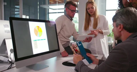 Multi-ethnic group having a quick team meeting at desk Video stock 61141118