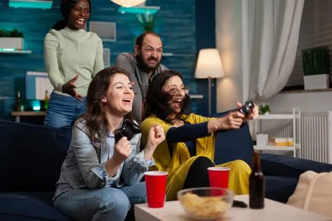 Multi ethnic group of people socializing winning at video games Stock Photos