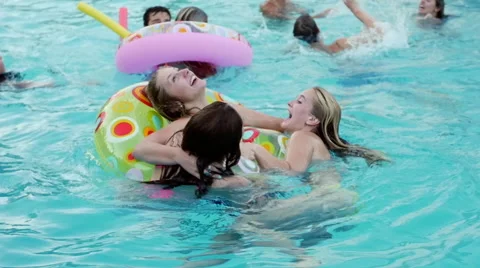 Multi-Ethnic Group of Teens Swim And Play At A Pool Party Видео 43614822