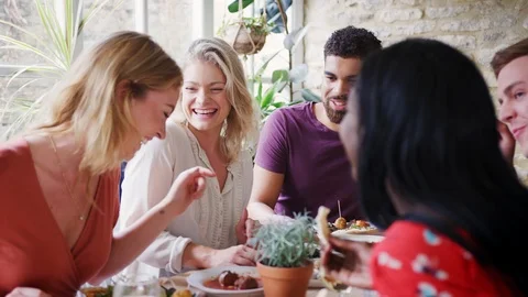 Multi-ethnic group of young adult friends eating lunch together at a restaurant, Stock Footage