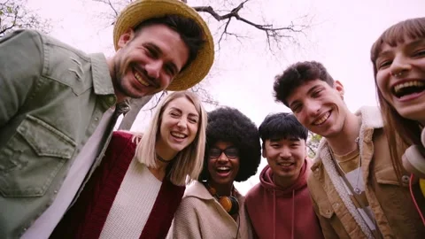 Multi-ethnic group of young friends smiling excited at camera in autumn outdoors Stock Footage 248838712