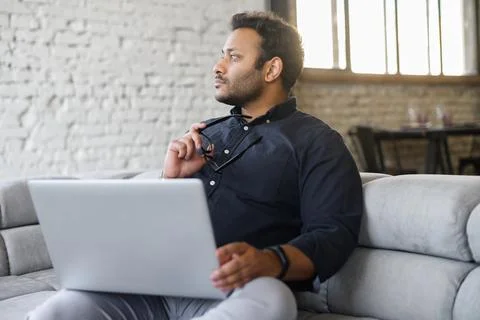 Multi-ethnic hindu freelancer guy using laptop computer at home Stock Photos