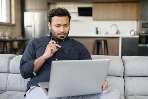 Multi-ethnic hindu freelancer guy using laptop computer at home Stock Photos