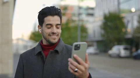 Multi-Ethnic Man Engages in Video Call with Charming Smile and Waving at the Stock Footage 242575264