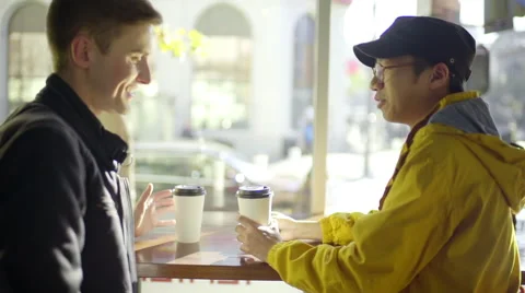 Multi-Ethnic Man Uses His Smartphone, His Boyfriend Arrives With Coffee Stock-Footage 47129629
