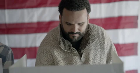 Multi-ethnic man voting at election booth. Camera moves from MS to CU Stock Footage 275201733