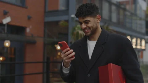 Multi ethnic man walking downtown, holding the new year present and happy Stock Footage 224839097